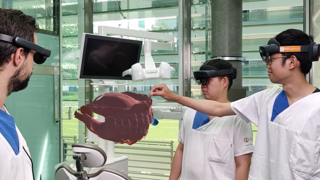 Medical professionals using AR headsets to examine a 3D model of human jawbones.