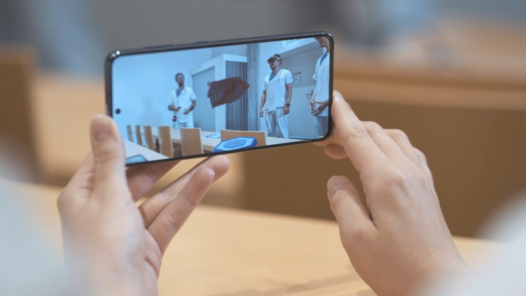Hands holding a smartphone displaying a medical training.